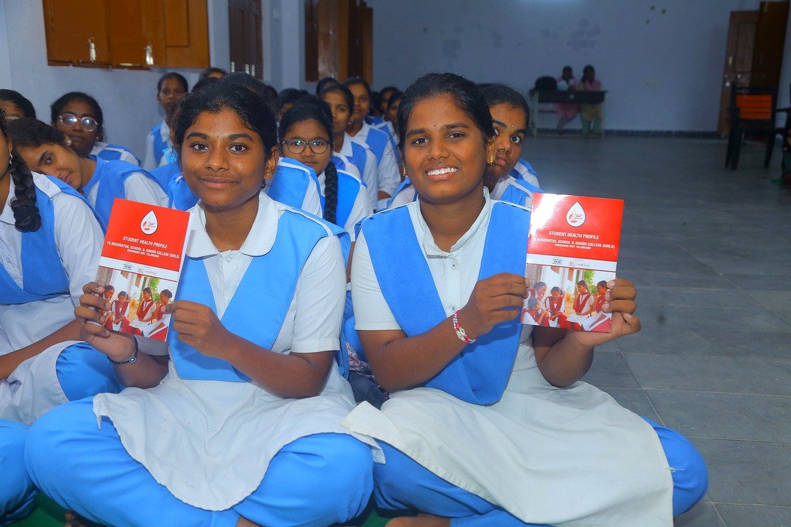 Adolescent students holding their student health profiles at a school anaemia awareness program